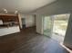 Open concept living space adjacent to kitchen with hardwood floors and a sliding door to outdoor space at 3408 Curlew Ave, Leesburg, FL 34748