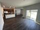 An open floor plan showcases the living room, kitchen, and modern dark wood-look flooring at 3408 Curlew Ave, Leesburg, FL 34748
