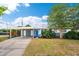 Charming single-story home featuring a bright blue door, covered parking, and mature landscaping at 3520 Sebring Ave, Orlando, FL 32806