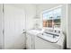 Bright laundry room with a window, modern washer and dryer, and white door at 3520 Sebring Ave, Orlando, FL 32806