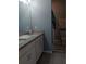 Bright bathroom featuring a double-sink vanity with granite countertops and a step-in shower at 3582 Forster Ave, Leesburg, FL 34748