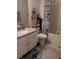 Bathroom with a granite countertop vanity and a shower-tub combination with a patterned curtain at 3582 Forster Ave, Leesburg, FL 34748