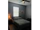 Bedroom featuring a ceiling fan, a large window, and beach-themed artwork at 3582 Forster Ave, Leesburg, FL 34748