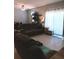 Cozy living room featuring tile floors, a ceiling fan, and a plush, reclining sofa at 3582 Forster Ave, Leesburg, FL 34748