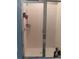 View of a white-tiled shower stall with a glass door and built-in shelves at 3582 Forster Ave, Leesburg, FL 34748
