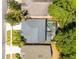 Aerial view showcases a home with a screened pool, surrounded by palm trees and landscaping at 4027 Lakeside Reserve Ct, Orlando, FL 32810
