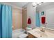 Well-lit bathroom with a shower-tub combo, tile surround, and a stylish blue shower curtain at 4027 Lakeside Reserve Ct, Orlando, FL 32810
