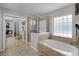 Well-lit bathroom with a soaking tub, a glass-enclosed shower, and tiled floors at 4027 Lakeside Reserve Ct, Orlando, FL 32810