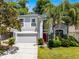 Two story home with well manicured lawn, landscaping, and red front door at 4027 Lakeside Reserve Ct, Orlando, FL 32810