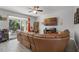 Living room with a large leather sofa and sliding glass doors to a patio at 4027 Lakeside Reserve Ct, Orlando, FL 32810