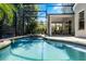 Sparkling pool and jacuzzi in a screened enclosure with an outdoor dining area at 4027 Lakeside Reserve Ct, Orlando, FL 32810