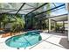 Inviting pool and jacuzzi in screened enclosure with an outdoor dining area at 4027 Lakeside Reserve Ct, Orlando, FL 32810