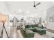 Spacious living area with a comfortable green sectional, ceiling fan, and bright, airy atmosphere at 4215 Swan St, Haines City, FL 33844