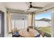 Covered patio has ceiling fan, wood table and chairs and a view of the white fenced backyard at 4215 Swan St, Haines City, FL 33844