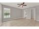 Bright bedroom with tile flooring, a ceiling fan, and a large window overlooking the backyard pool area at 4347 Creekside Blvd, Kissimmee, FL 34746