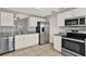 Updated kitchen featuring stainless steel appliances, granite countertops, and white cabinetry at 4347 Creekside Blvd, Kissimmee, FL 34746
