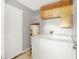 Functional laundry room with washer, dryer, water heater, and cabinets at 4347 Creekside Blvd, Kissimmee, FL 34746