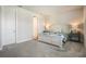 Comfortable carpeted bedroom with neutral walls, a well-dressed bed, and decorative side tables at 4591 Gliding Wave St, Winter Garden, FL 34787