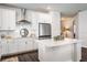 Bright white kitchen featuring stainless steel appliances, a tiled backsplash, and a quartz island with breakfast bar at 4591 Gliding Wave St, Winter Garden, FL 34787