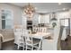 Open-concept kitchen and dining area with white cabinets, stainless appliances, and stylish chandelier at 4591 Gliding Wave St, Winter Garden, FL 34787