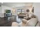 Open living room with dark wood floors, comfy seating, and sliders to the backyard at 4591 Gliding Wave St, Winter Garden, FL 34787