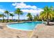 Community swimming pool features a modern entrance, with palm trees and lounge chairs nearby at 4591 Gliding Wave St, Winter Garden, FL 34787