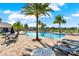 Beautiful community pool with lounge chairs and palm trees against a bright blue sky in a Gathering neighborhood at 4591 Gliding Wave St, Winter Garden, FL 34787