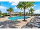 Community pool surrounded by lounge chairs, palm trees, and lush landscaping in a residential neighborhood at 4591 Gliding Wave St, Winter Garden, FL 34787