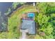 Aerial view of a home with a screened pool and lush surrounding landscape near the water at 516 Fort Smith Blvd, Deltona, FL 32738