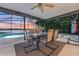 Outdoor dining setup with a scenic lake view within a screened-in patio at 516 Fort Smith Blvd, Deltona, FL 32738