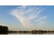 Scenic view of calm lake waters with a wispy, white cloud and blue sky above at 516 Fort Smith Blvd, Deltona, FL 32738