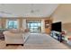Spacious living room with plush sofa, a sliding door to the outdoor pool area, and a view to the lake at 516 Fort Smith Blvd, Deltona, FL 32738