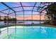 Screened-in pool with a beautiful lake view at sunset at 516 Fort Smith Blvd, Deltona, FL 32738