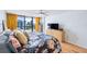 Bright bedroom featuring a city view, floral bedding, and hardwood floors at 530 E Central Blvd # 1702, Orlando, FL 32801