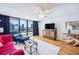 Comfortable living room with balcony access, hardwood floors, and stylish furnishings at 530 E Central Blvd # 1702, Orlando, FL 32801