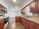 Well-equipped kitchen with dark wood cabinets, granite counters, and modern appliances at 5481 Nokomis Cir, Orlando, FL 32839