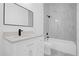 White bathroom featuring marble tile and a shower and tub combination at 600 Lakewood Ave, Ocoee, FL 34761