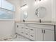 Bathroom featuring double vanity with modern fixtures, two round mirrors and lots of storage at 600 Lakewood Ave, Ocoee, FL 34761