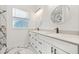 Bright bathroom featuring double vanity, black fixtures, and marble-tiled shower at 600 Lakewood Ave, Ocoee, FL 34761