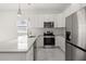 Modern kitchen boasts stainless steel appliances, white cabinetry, subway tile backsplash, and quartz countertops at 600 Lakewood Ave, Ocoee, FL 34761