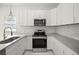 Updated kitchen boasts white cabinets, stainless steel appliances, quartz countertops, and modern fixtures at 600 Lakewood Ave, Ocoee, FL 34761