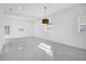 Open living room with marble flooring, a modern light fixture, and natural light from windows at 600 Lakewood Ave, Ocoee, FL 34761
