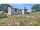 Backyard featuring a grassy area and home exterior with windows and an AC unit at 619 Carver Dr, Lake Wales, FL 33853