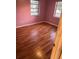 Cozy bedroom with wood-look flooring, two windows, and soft pink walls at 636 S Wellington Dr, Deltona, FL 32725