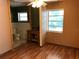 Bedroom with tan walls, desk, wood floors, window, and attached bathroom at 636 S Wellington Dr, Deltona, FL 32725