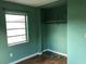Bedroom with green walls, wood floors, a window, and a closet at 636 S Wellington Dr, Deltona, FL 32725