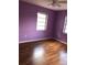 Bedroom featuring purple walls, wood floors, and a window at 636 S Wellington Dr, Deltona, FL 32725