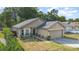 Home featuring a two-car garage, well-kept lawn, and an inviting front entrance with some foliage at 6701 Belmar Dr, Orlando, FL 32807
