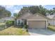 Inviting single-story home with a two-car garage, lush lawn, and a welcoming front entrance at 6701 Belmar Dr, Orlando, FL 32807