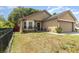 Home featuring a two-car garage, well-kept lawn, and an inviting front entrance with some foliage at 6701 Belmar Dr, Orlando, FL 32807